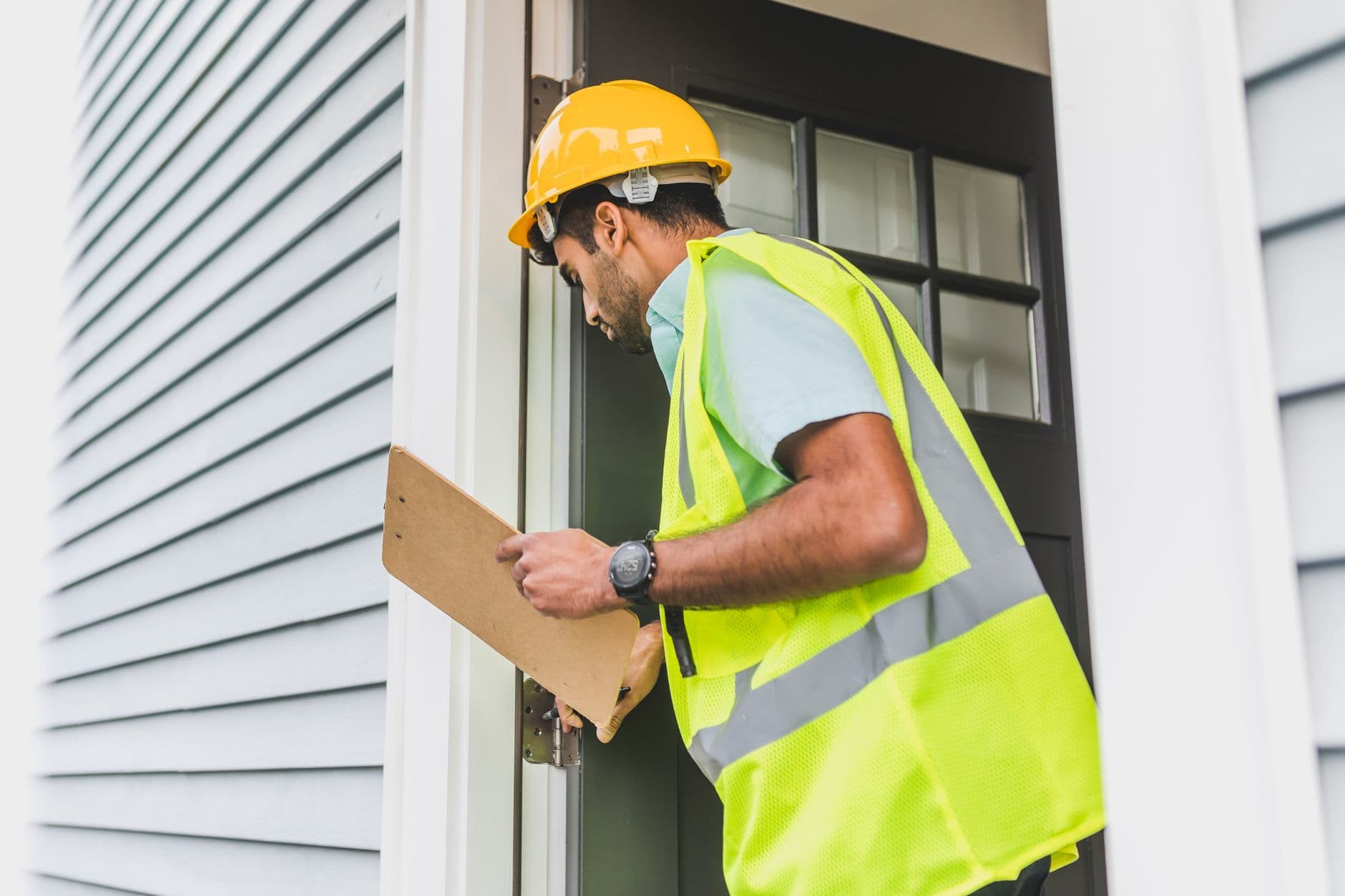 Pest control applicator reviewing a treatment log inside a commercial warehouse facility