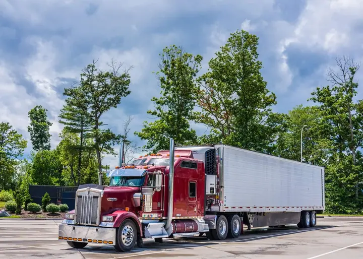 Fleet manager reviewing DOT compliance paperwork with a driver at a warehouse dock