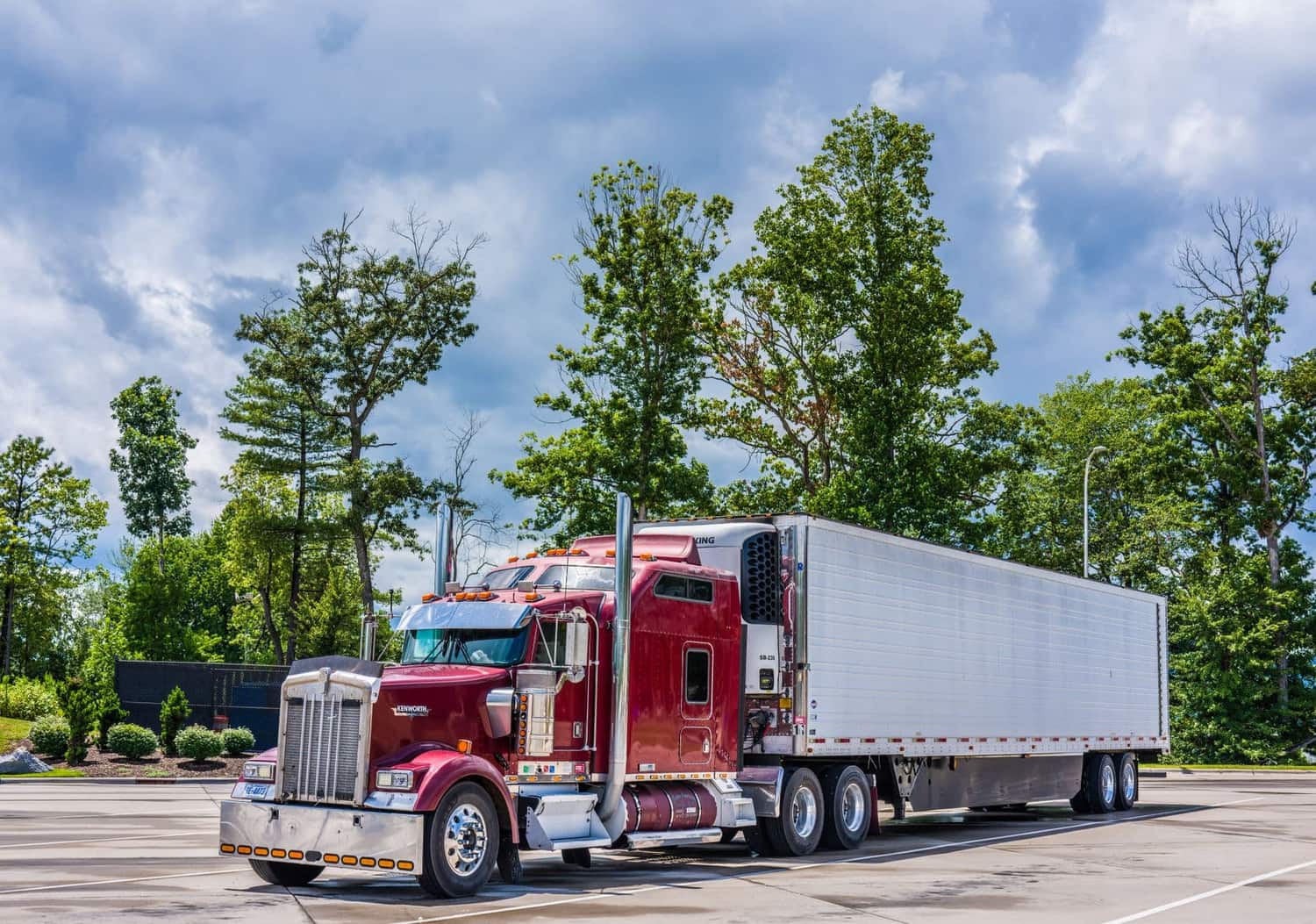 Fleet manager reviewing DOT compliance paperwork with a driver at a warehouse dock