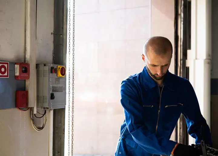 Elevator mechanic servicing a control panel in a commercial building machine room