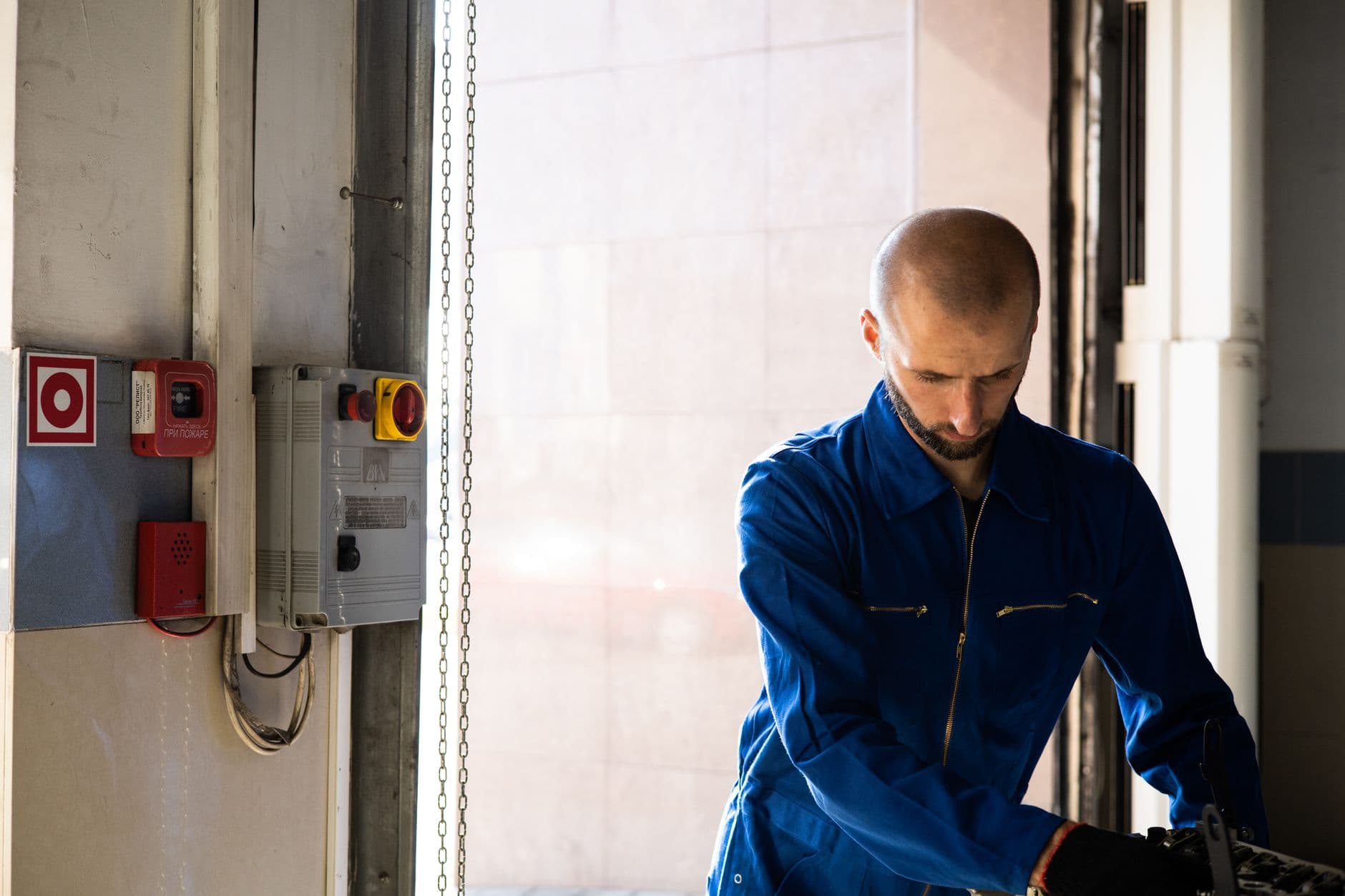Elevator mechanic servicing a control panel in a commercial building machine room