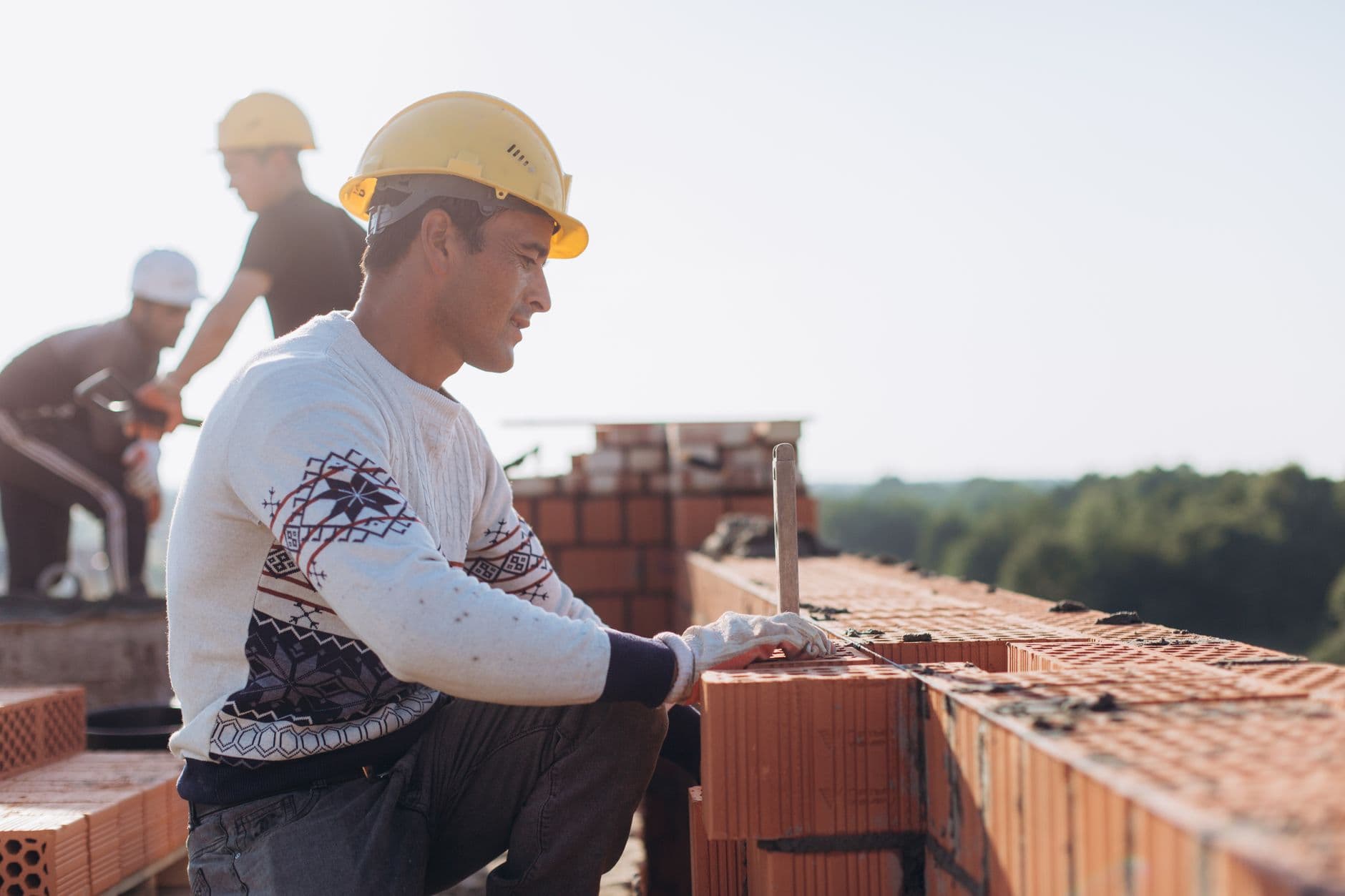 Bricklayer setting concrete block on a commercial jobsite wall