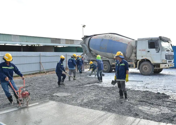 Concrete finisher troweling a fresh commercial slab pour