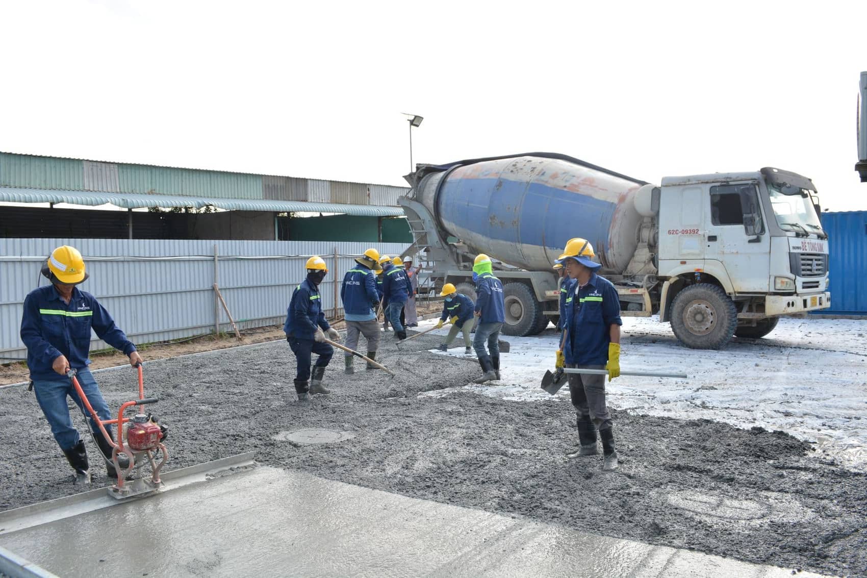 Concrete finisher troweling a fresh commercial slab pour