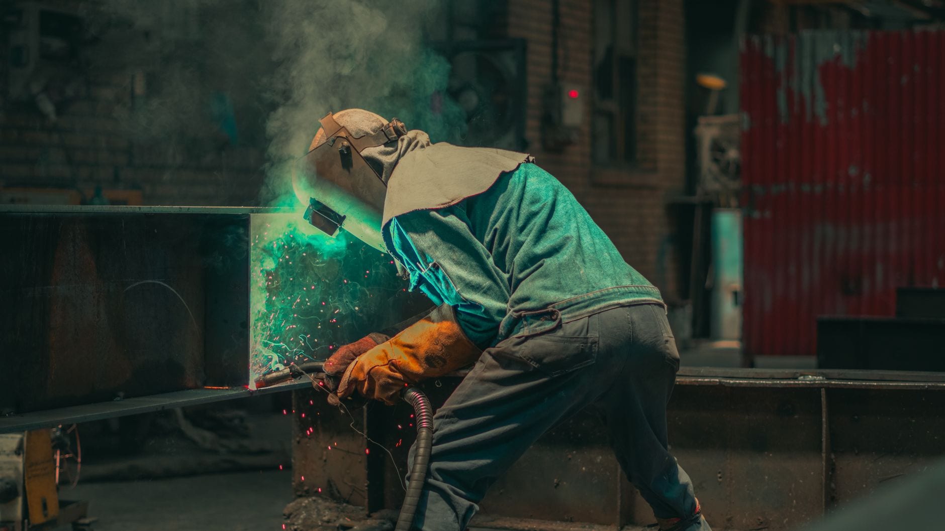 Welder in safety gear working on a metal fabrication project