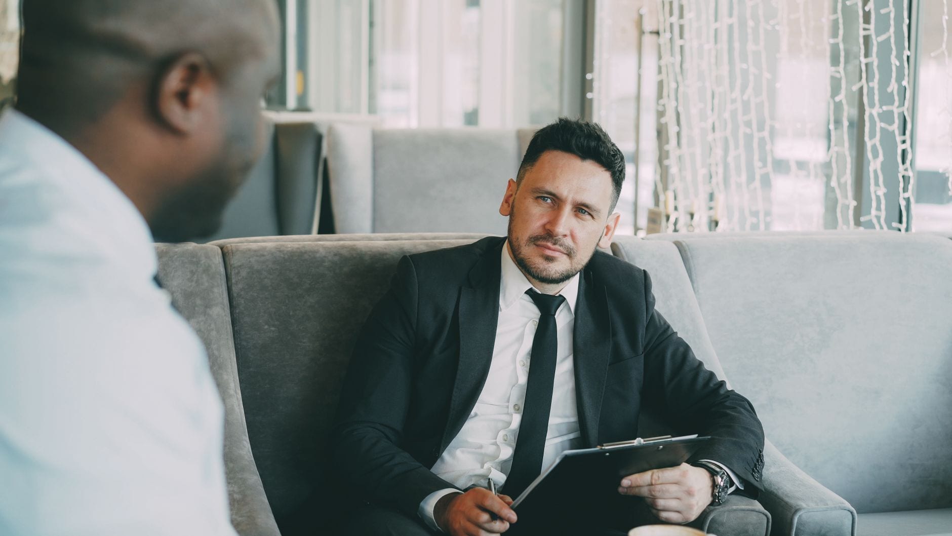 Two businessmen engaged in a professional conversation indoors.